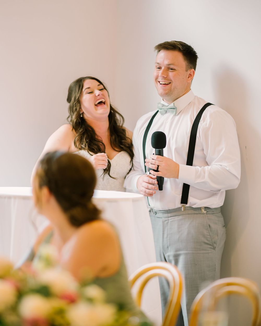 Bride and groom laughing during a wedding speech