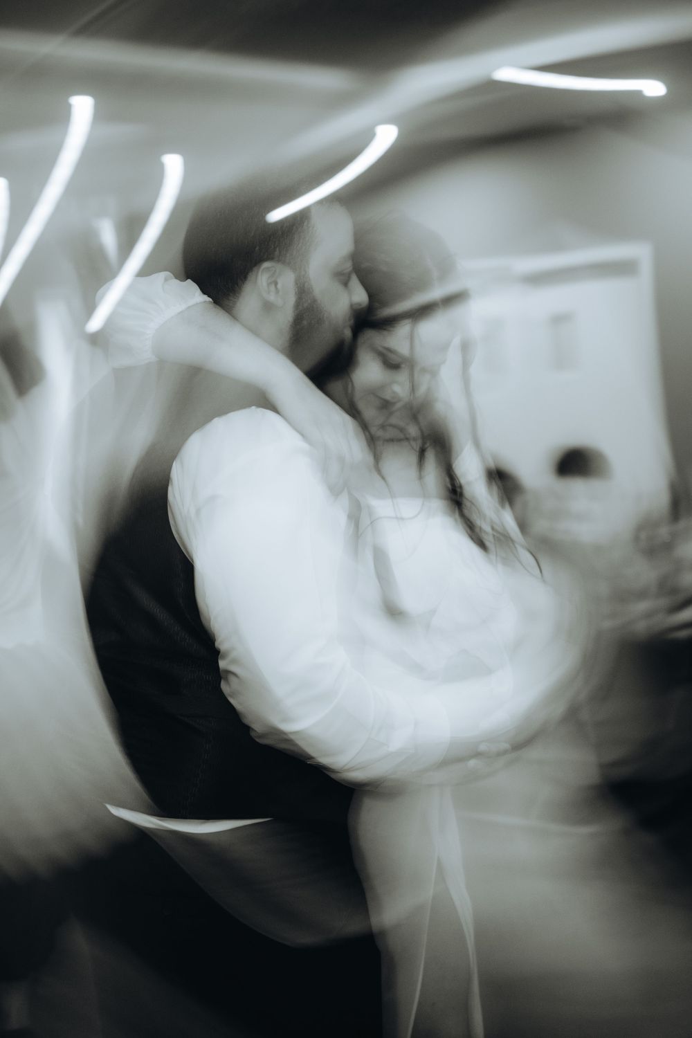 Newlyweds embracing during a lively dance