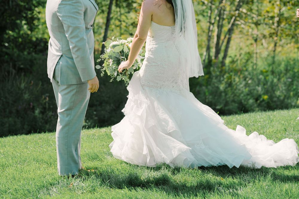 Bride and groom walking through green grass